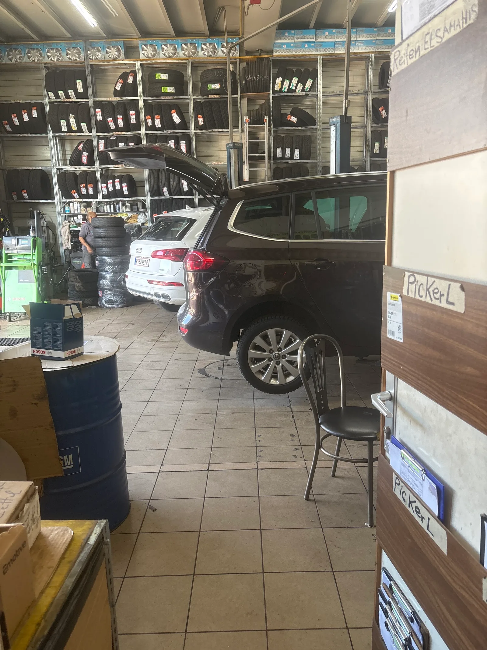 Ein Opel in der Werkstatt neben einem Pickerl Schild