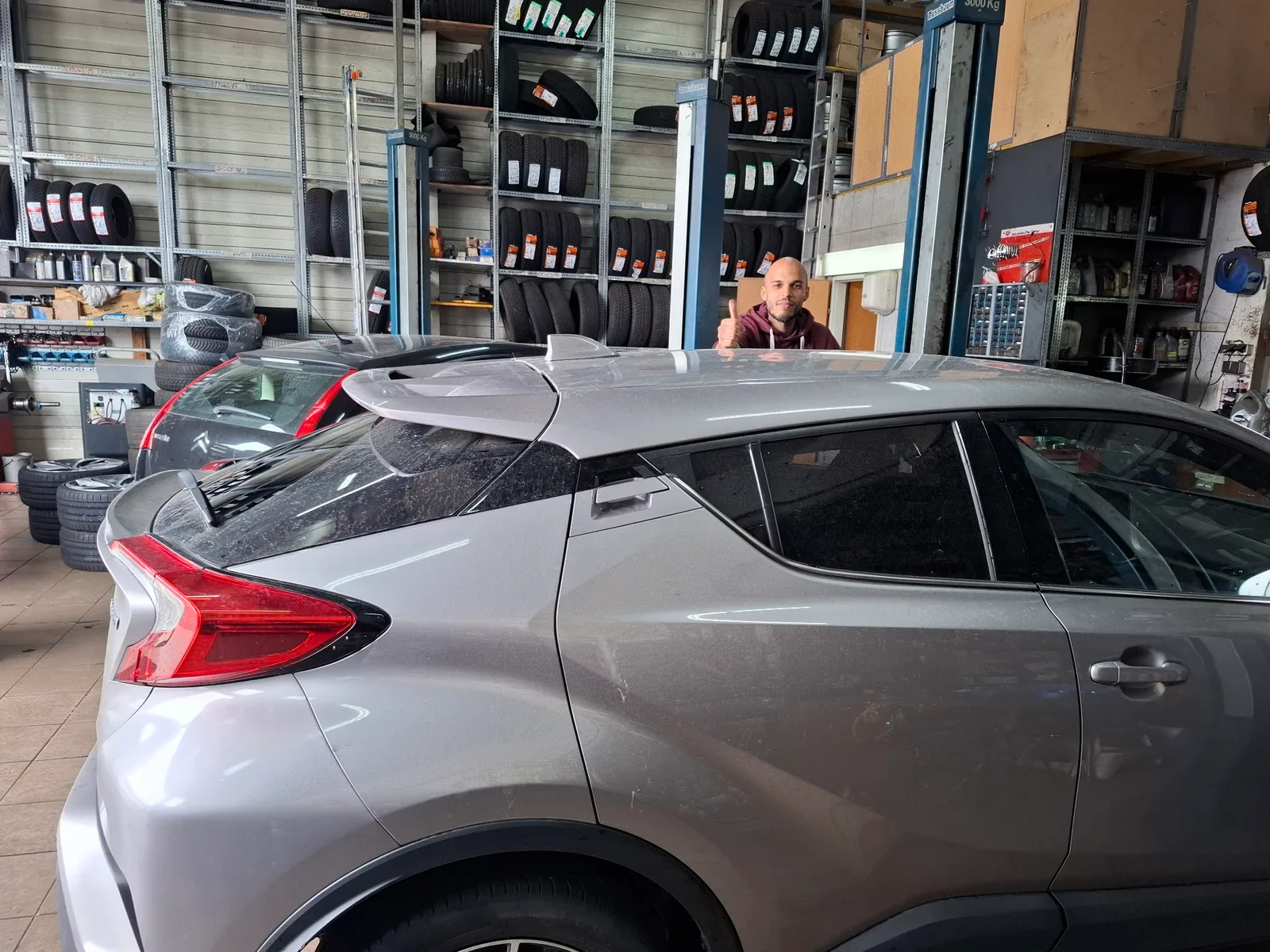 Ein Toyota C-HR in der Werkstatthalle vor Reifenregalen